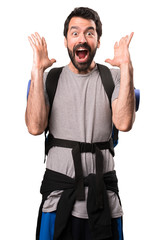 Naklejka premium Handsome backpacker making surprise gesture on white background