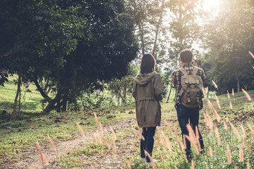 Two Young Traveler with backpack, are holding map relaxing in greens jungle and enjoying with outdoor forest on background Summer vacations and Lifestyle hiking concept