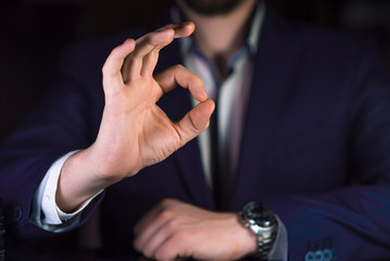 Businessman showing OK by his hand.  Reliable business or service concept