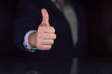 Businessman showing thumb up on dark background. Successful business concept. Place for text or desing