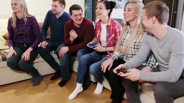 Happy group of male friends playing video games at home