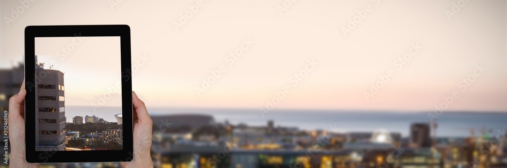 Wall mural Composite image of close-up of hands holding digital tablet