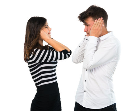 Young couple covering both ears with hands on isolated white background