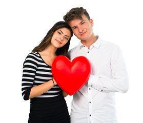 Young teenager couple holding a heart toy on isolated white background