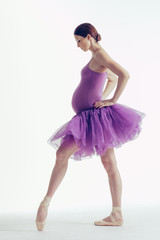 Young beautiful ballerina is posing in studio