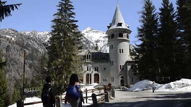 Gressoney-Saint-Jean, Valle d 'Aosta region, Italy. April 25 2018. Castel Savoia, is a villa built in the late 1800s in eclectic style. A fairytale setting, a view of the entrance with tourists.