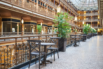 Chair and table for dining at the Old Arcade in Downtown Cleveland. Given National Historic Landmark status in 1975, the Arcade in downtown Cleveland is Victorian - obrazy, fototapety, plakaty
