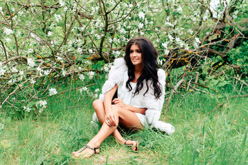 beautiful young girl in white dress in spring blossoming apple orchards