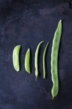 Various sorts of beans and peas on dark metal