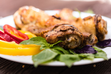 Roasted chicken quarter legs on rustic background