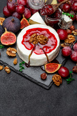 Camembert cheese and walnuts on stone serving board
