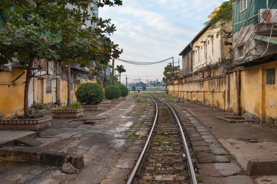 Vietnam. Railway crossing the street betwyn residential houses in Hanoi city