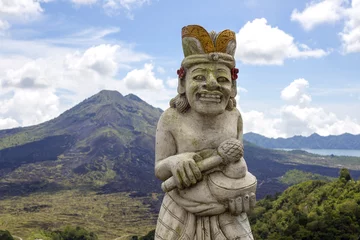 Outdoor-Kissen Traditional Balinese sculpture against the background of the volcano Batur. Island Bali, Indonesia © OlegD
