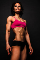Fototapeta na wymiar Fitness woman posing against a black background