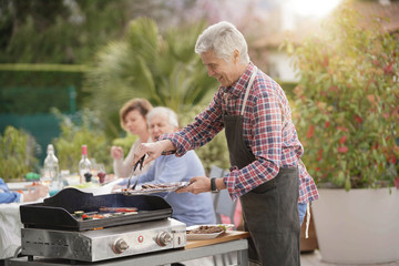 Group of senior people preparing barbecue lunch