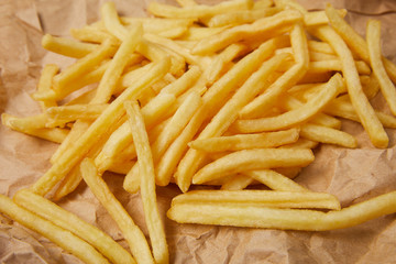 close-up shot of delicious french fries spilled over crumpled paper