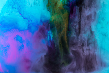 creative texture with purple and blue paint swirls in water