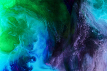 creative background with blue, purple and green paint swirls looks like space