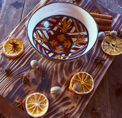 Dishes stand on wooden tray decorated with oranges and nuts