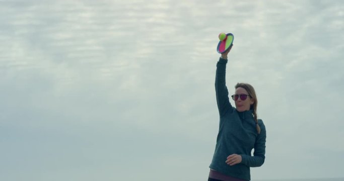 Woman on beach throwing a ball