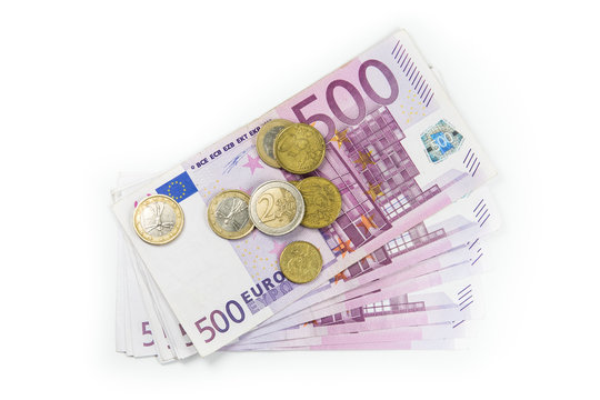 Stack of Euro banknotes and coins isolated. 500 Euro banknotes. European currency money banknotes isolated on white backdrop. Top view closeup. Salary, savings, european union economic crisis concept.