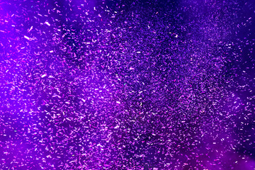 Hundreds of confetti fired on air during a festival at night. Image ideal for backgrounds. Blue tonality. Smoke in the middle of the confetti