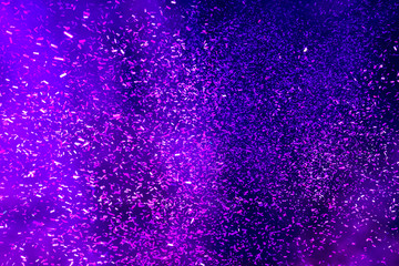 Hundreds of confetti fired on air during a festival at night. Image ideal for backgrounds. Blue tonality. Smoke in the middle of the confetti