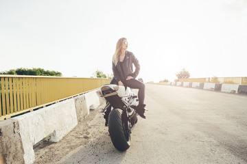 Beautiful woman biker posing sitting on a motorbike