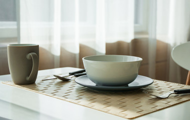 Wooden table with cup and dish in modern dinning room at home.