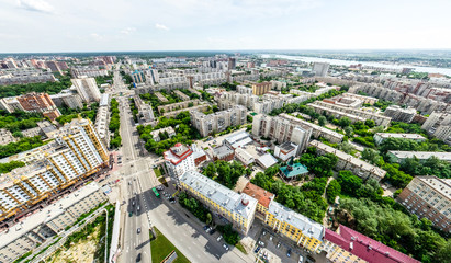 Obraz premium Aerial city view with crossroads and roads, houses, buildings, parks and parking lots, bridges. Helicopter drone shot. Wide Panoramic image.