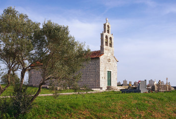 Fototapeta na wymiar Small stone church with churchyard. Montenegro, church of Saint Ivan in Tivat village Bogisici