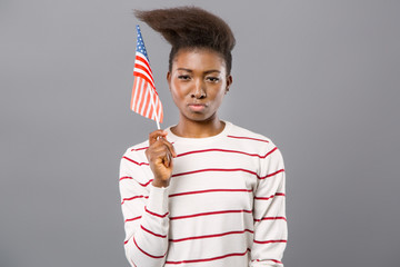 Multinational state. Confident young woman smiling while showing American flag to you