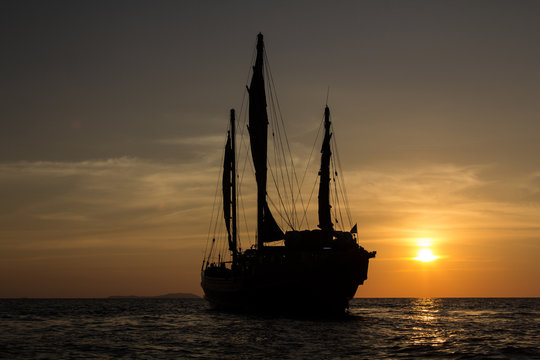 Old fashioned Chinese junk sailing into the sunset of the Indian ocean