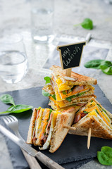 Delicious sandwich with ham, cheese, eggs, lettuce. High club sandwich with toast.