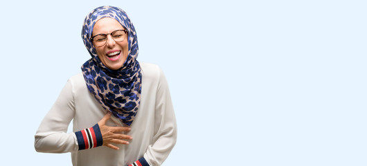 Middle age muslim arab woman wearing hijab confident and happy with a big natural smile laughing isolated blue background