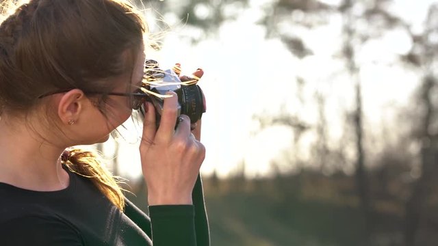 Beautiful girl takes pictures of her beloved man on a film camera
