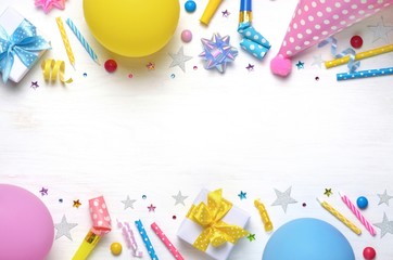Holiday frame or background with colorful balloon, gift, confetti, silver star, carnival cap and...