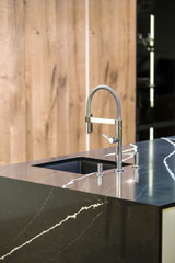 Kitchen faucet, modern kitchen in loft style, black marble table, wooden luxury kitchen