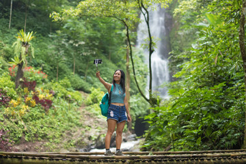 Naklejka na ściany i meble Tourist womantaking a selfie in Jungle