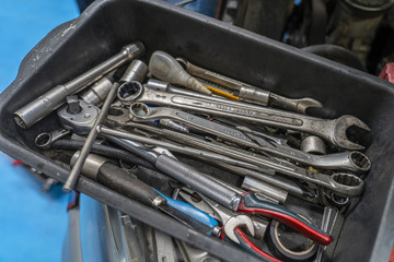Tool box of hand tools with old and dirty, rusty wrenches, ring spanners, pliers, screwdrivers, chisel and other do-it-yourself (DIY) tools.