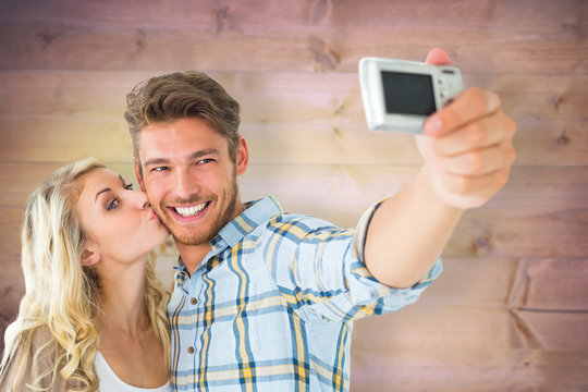 Attractive couple taking a selfie together against wooden planks