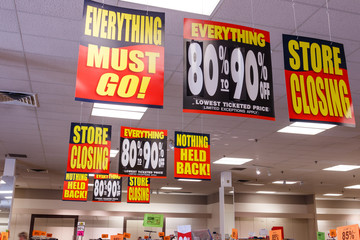 Store Closing and huge discount signs displayed at a going out of business sale III