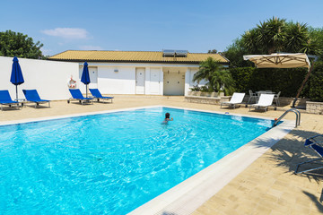 Little girl swimming in an outdoor pool