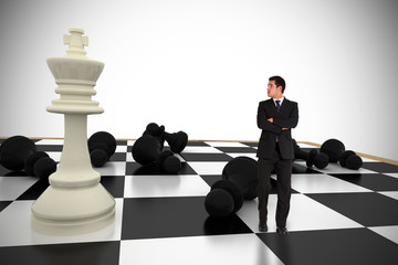 Businessman standing and looking with chessboard against white background with vignette