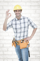 Handyman gesturing OK sign against white wall