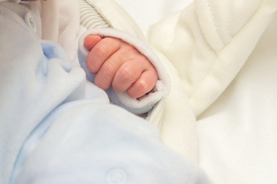 Little a newborn baby hand clenched in cam