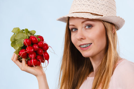 Happy woman biting radish