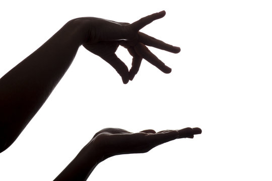 silhouette of female hands holding something over hand on an isolated white background