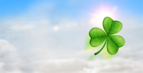 Shamrock against blue sky with white clouds