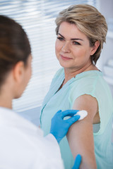 Obraz premium Doctor rubbing patient arm from cotton before injection